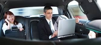 A man in a limo using his laptop
